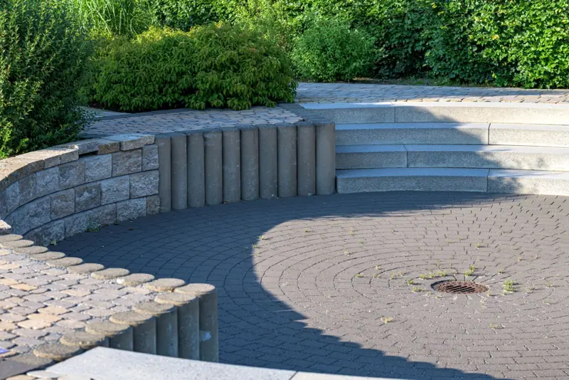 Rond terras met keerwand en traptreden in een groene tuin